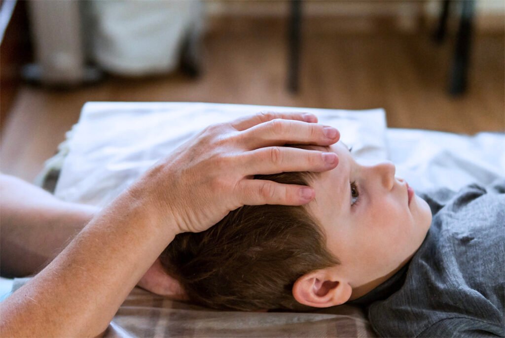 Cranial osteopathy treatment shown with an osteopath gently supporting a child’s head.